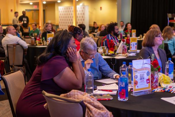 Tables of people listening to a presentation