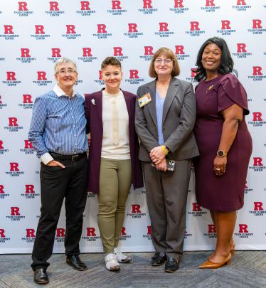 Four Rutgers staff and event panelists pose for a photo in front of a Tyler Clementi Center backdrop