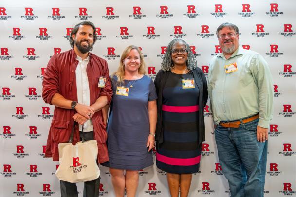 Four Rutgers staff and event panelists pose for a photo in front of a Tyler Clementi Center backdrop