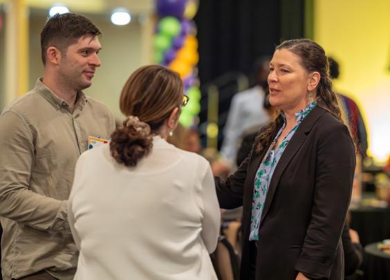 Three people standing and chatting