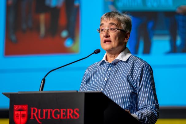 A person speaking at a podium with the Rutgers logo on the front