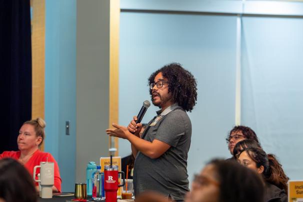 A crowd member speaking into a microphone