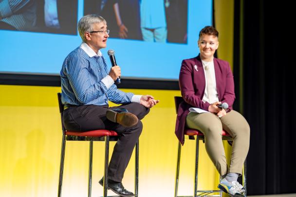 Two panelists seated on a stage