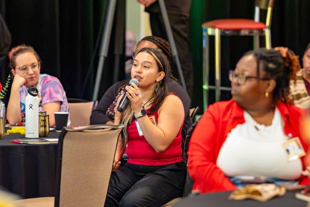 A crowd member speaking into a microphone