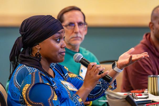 A seated audience member speaking into a microphone